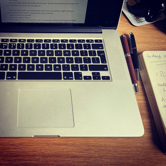 The tools of a writer. A computer, a notepad, a pen, and of course, a cup of coffee.